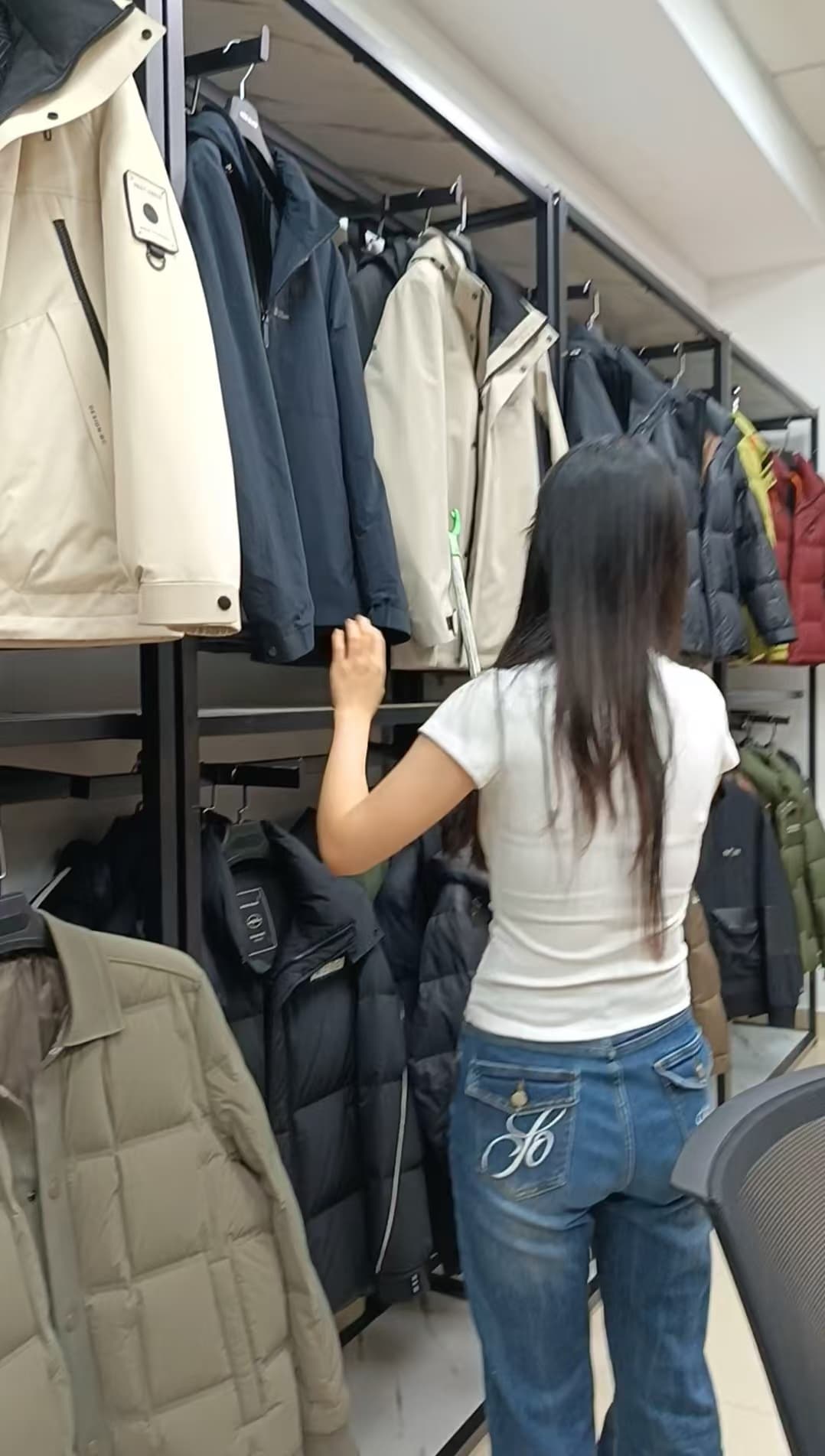 Team member reviewing jackets on a garment rail